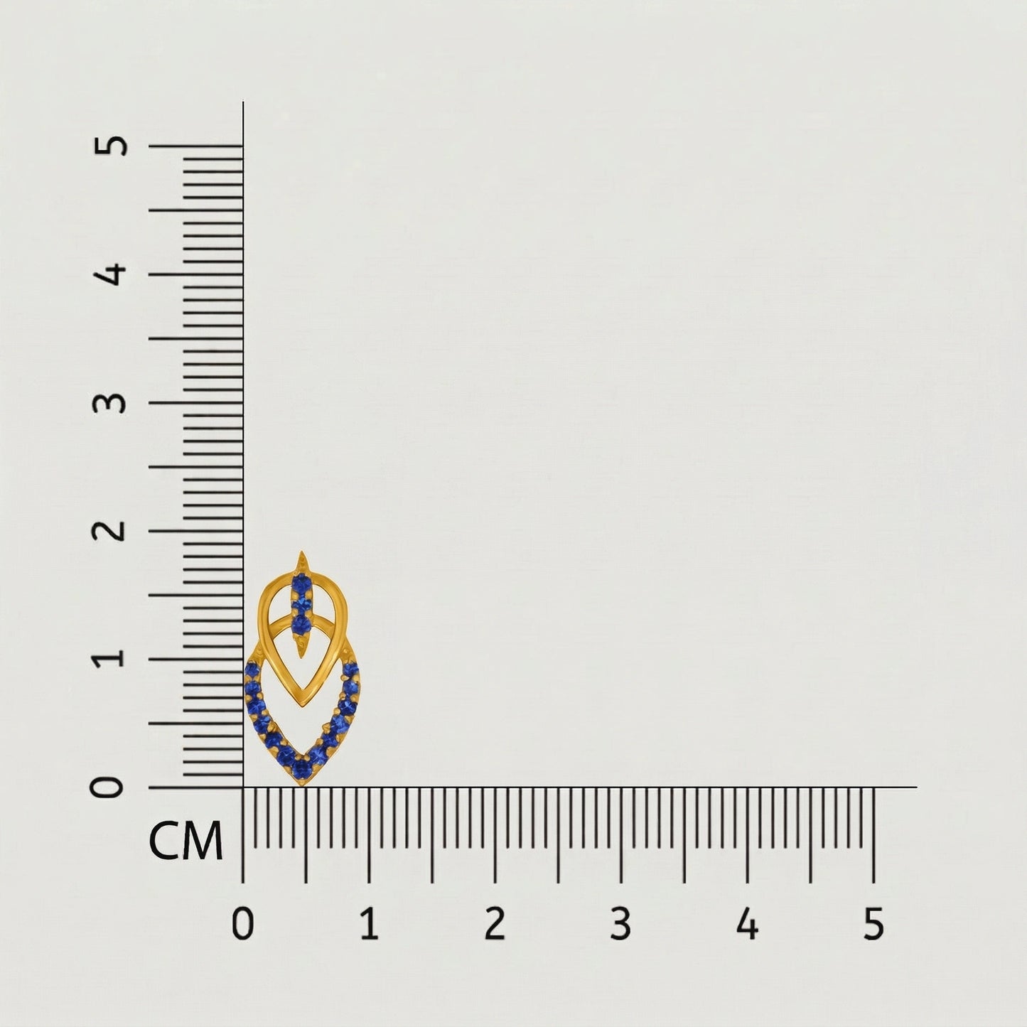 jewelry with blue stones and 18k gold plated accents next to a ruler on a gray background