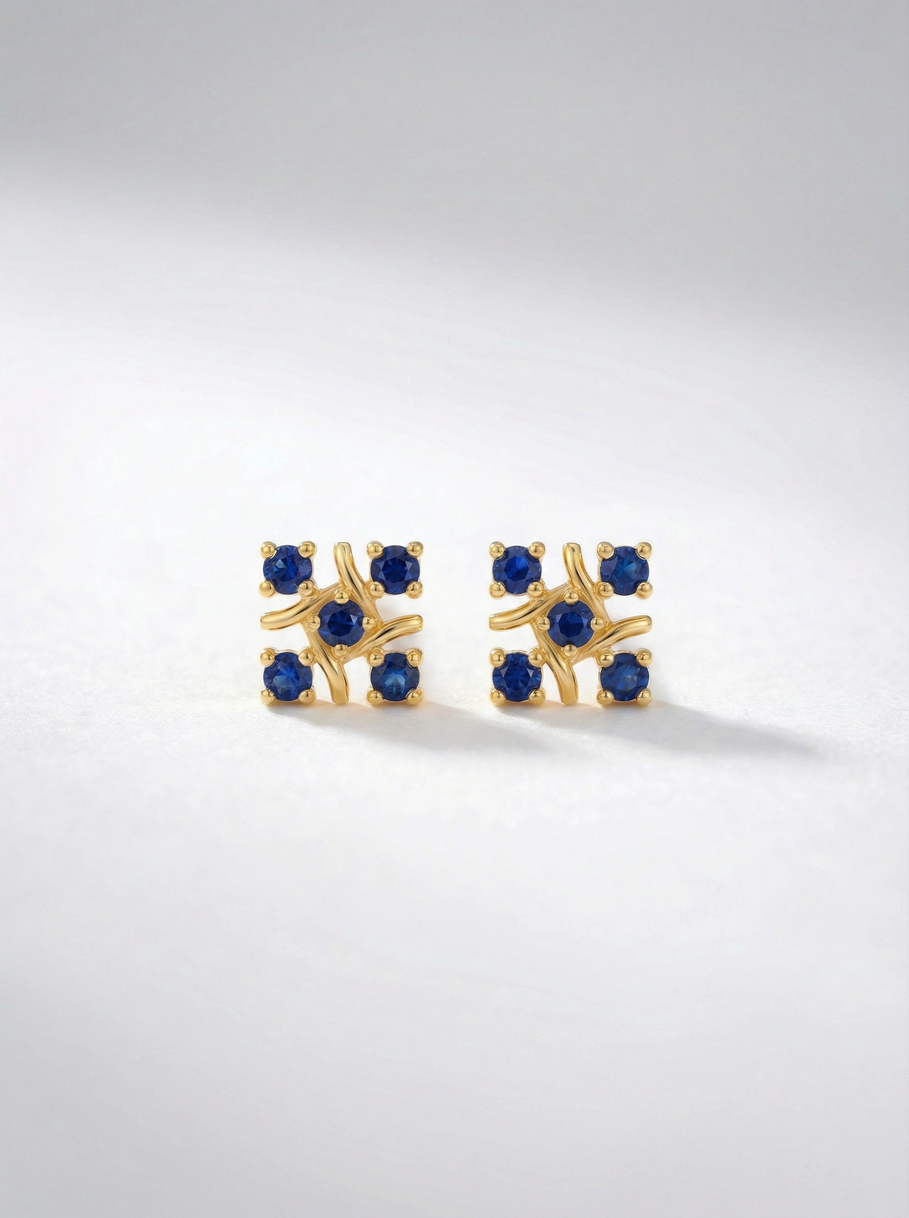 `8k Gold plated earrings with blue gemstones on a light gray background