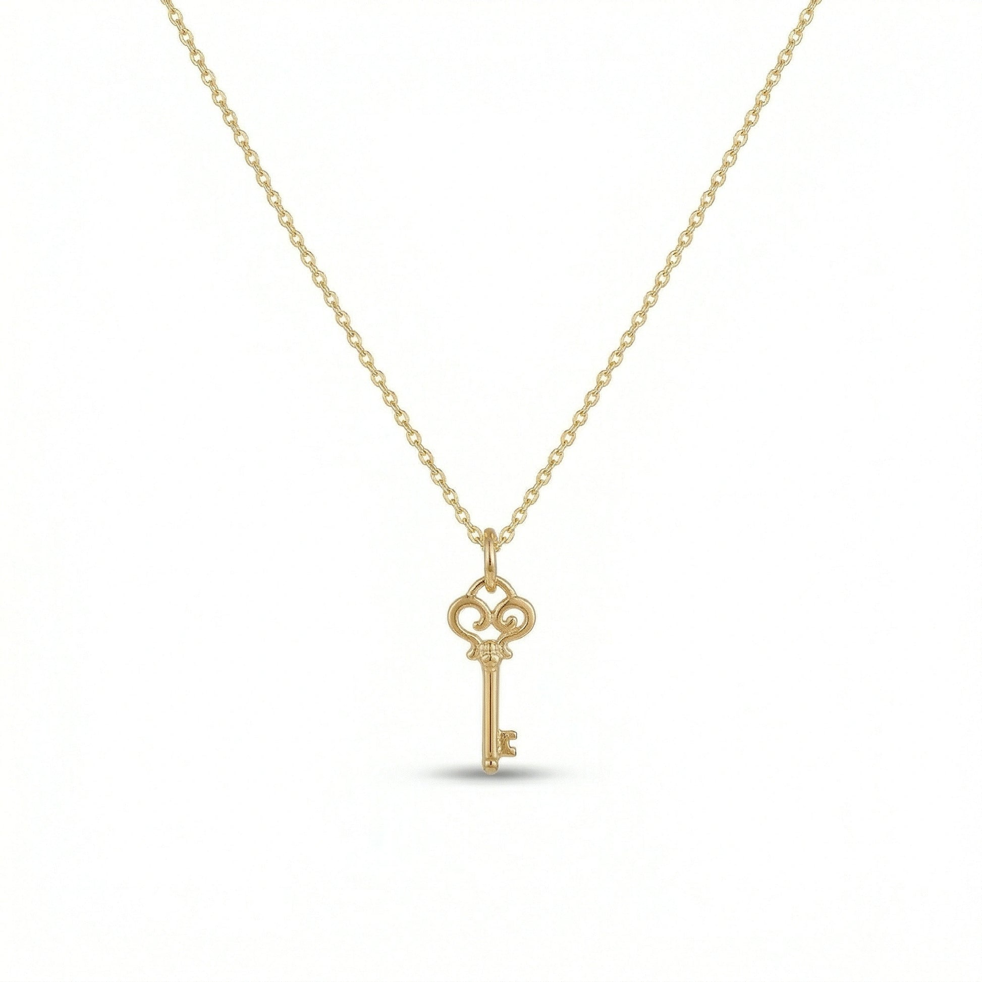 18k Gold  plated  key-shaped pendant on a chain against a white background