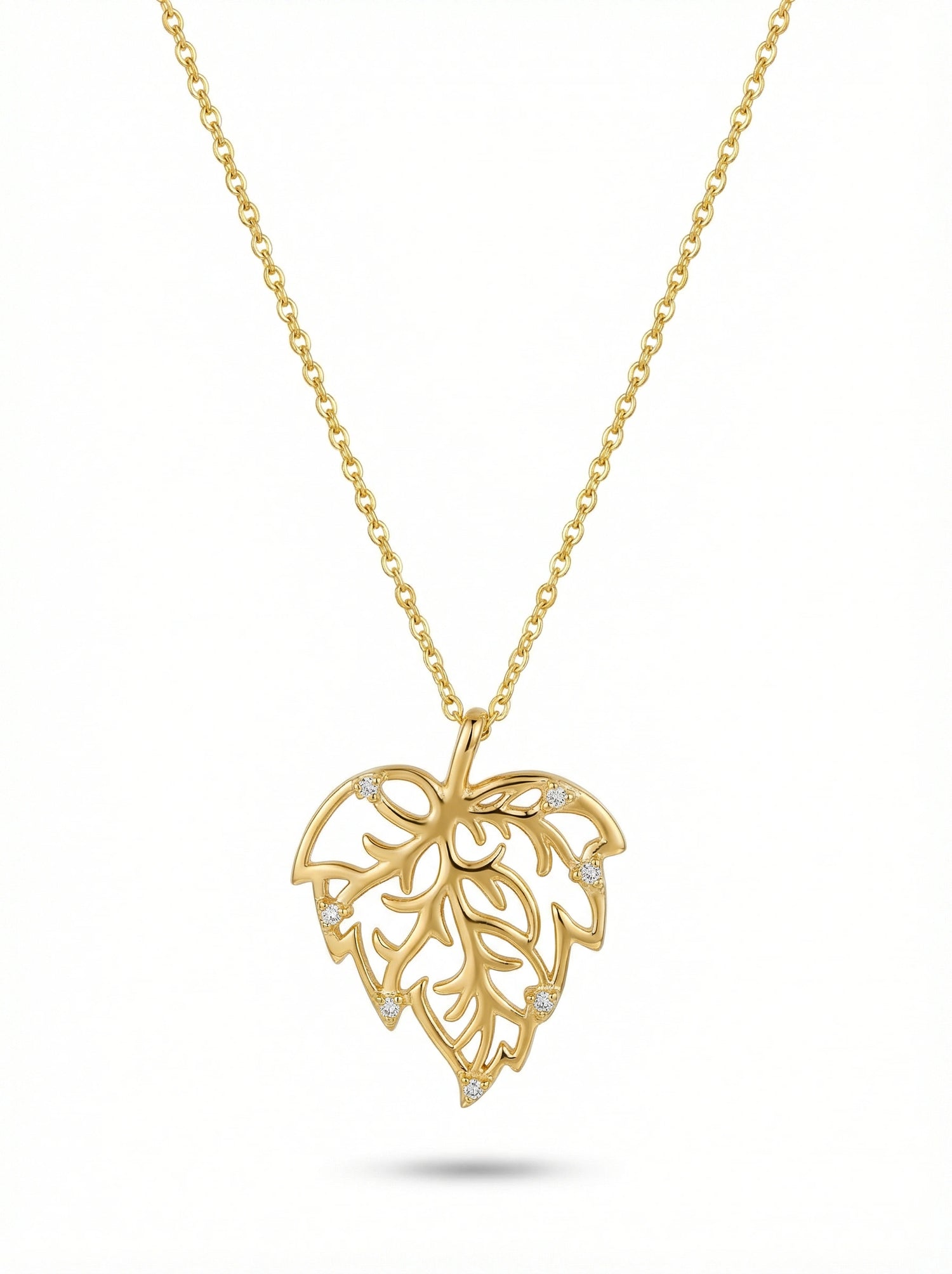 Gold necklace with a leaf-shaped pendant on a white background
