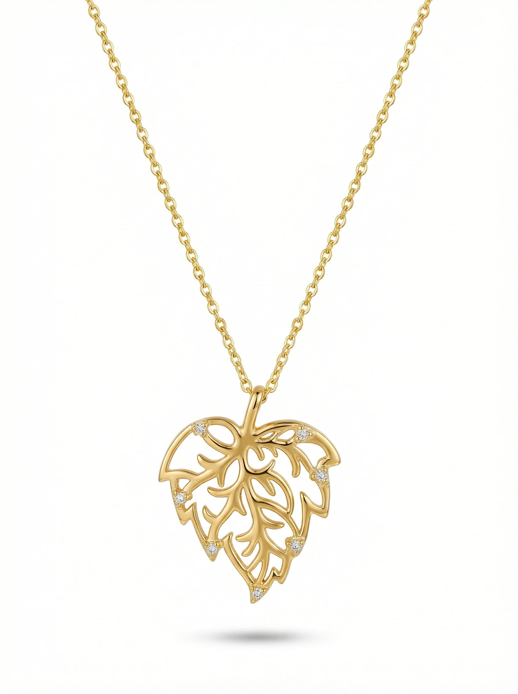 Gold necklace with a leaf-shaped pendant on a white background