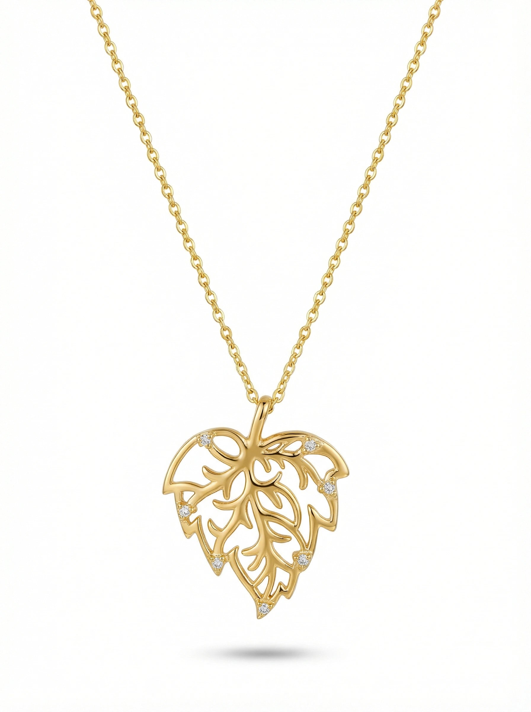Gold necklace with a leaf-shaped pendant on a white background