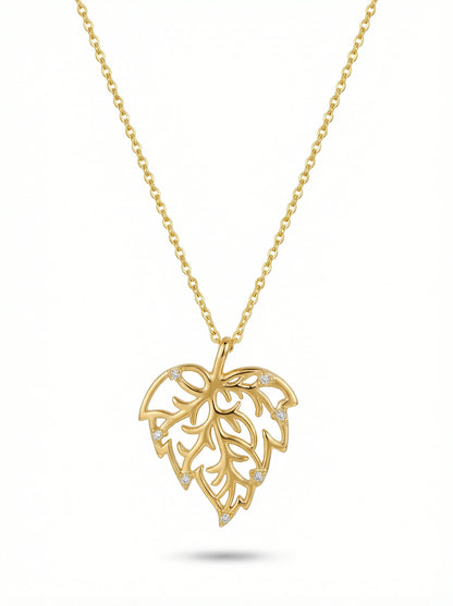 Gold necklace with a leaf-shaped pendant on a white background