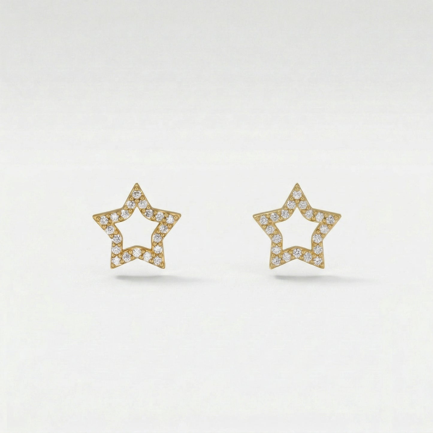 star-shaped 18k gold plated earrings with diamond accents on a light gray background