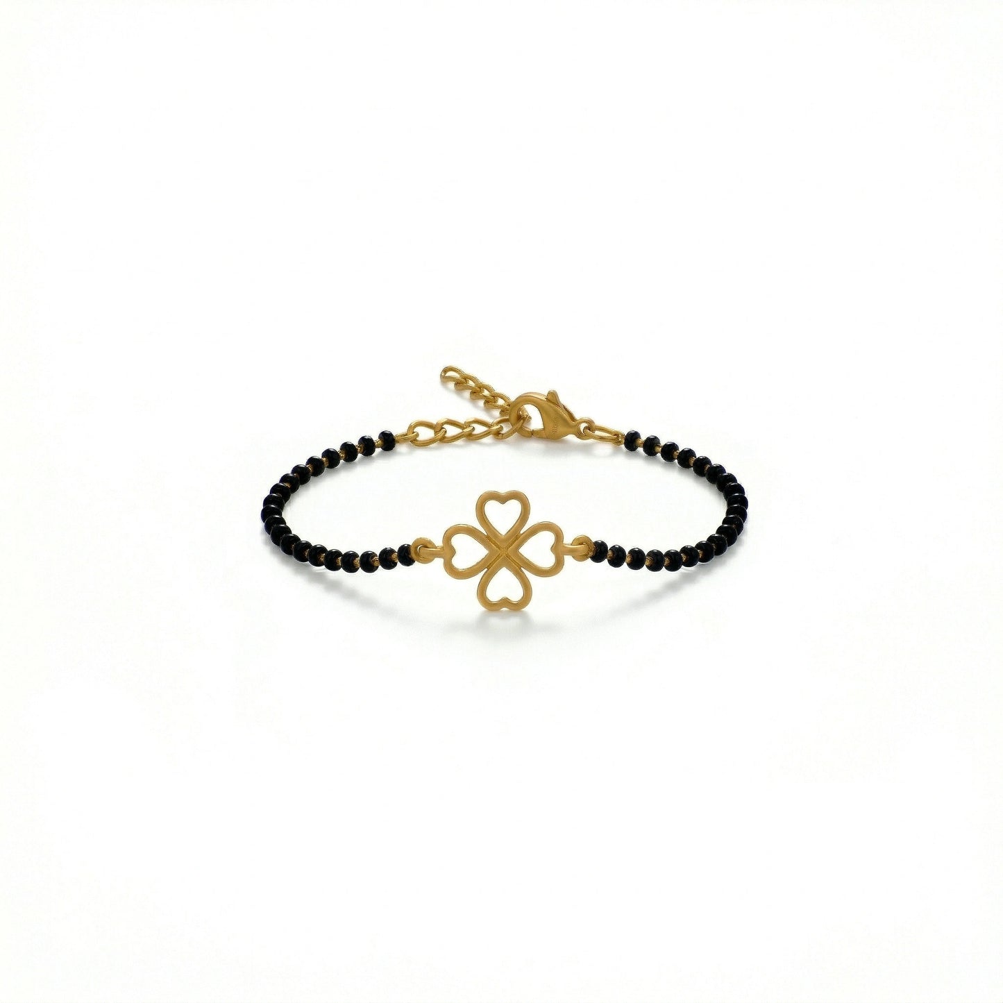 gold bracelet with black beads and clover charm on a white background