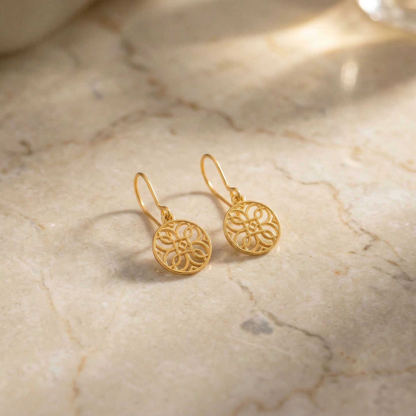 18k gold plated earrings on a marble surface