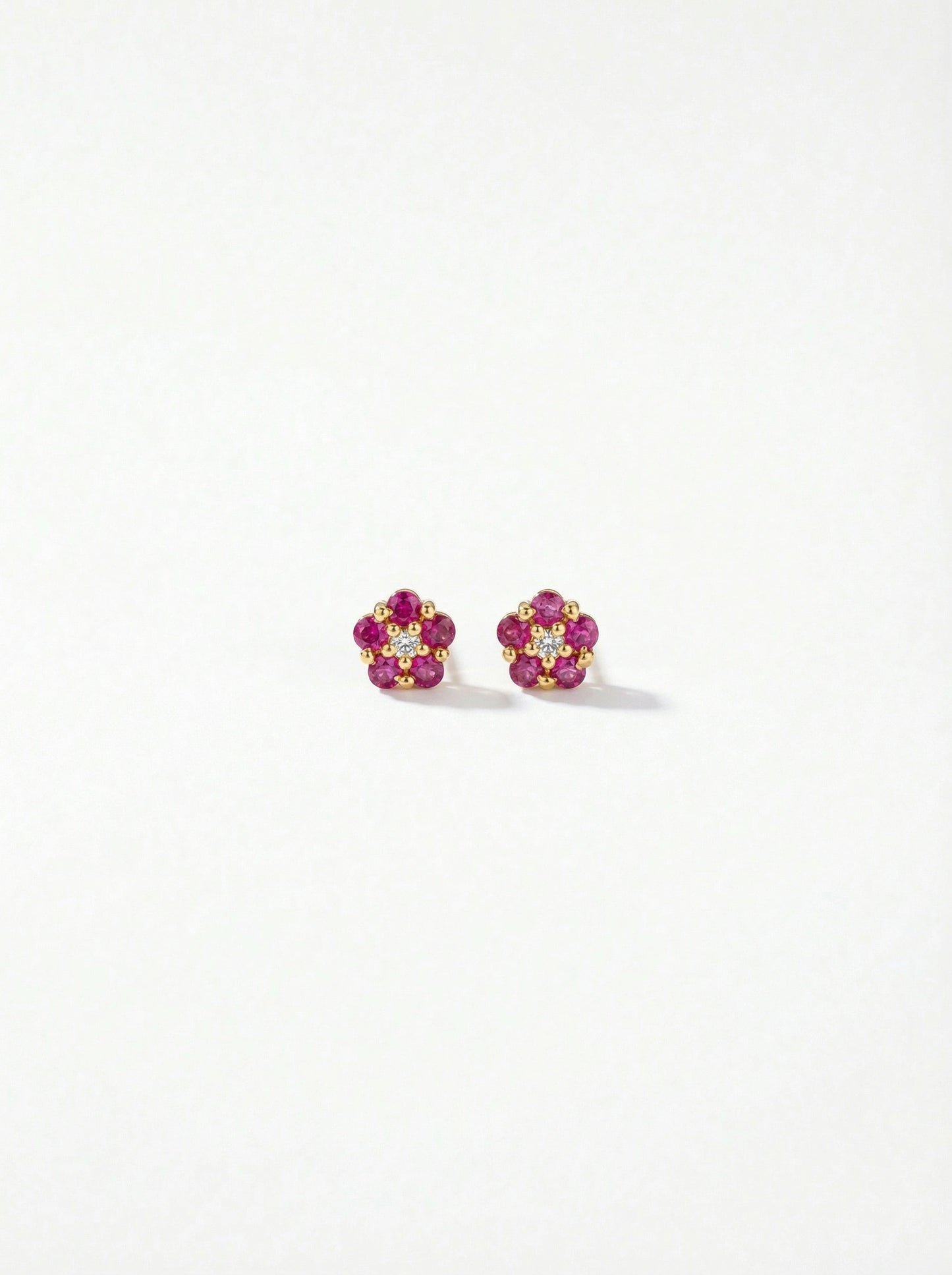 pair of flower-shaped earrings with 18k gold plated pink and yellow stones on a white background