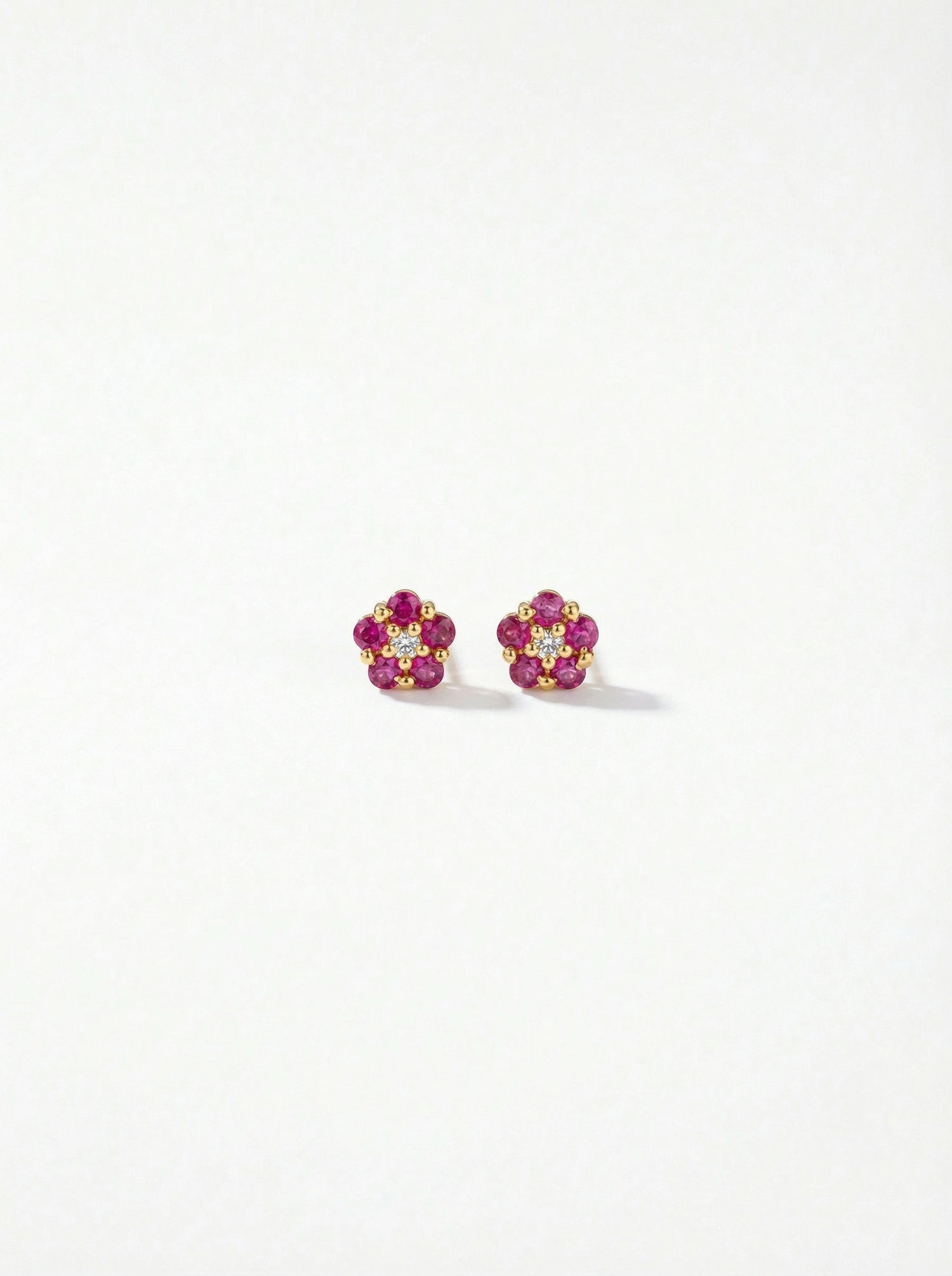 Pair of flower-shaped earrings with 18k gold plated pink and yellow stones on a white background