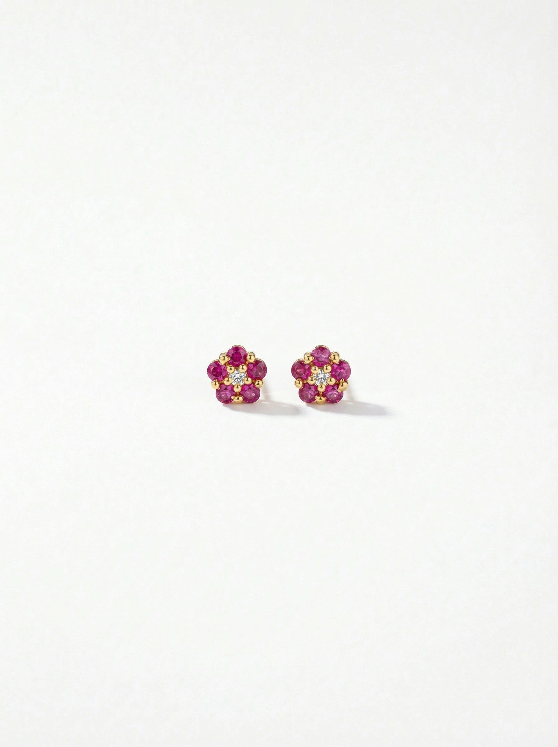 Pair of flower-shaped earrings with 18k gold plated pink and yellow stones on a white background