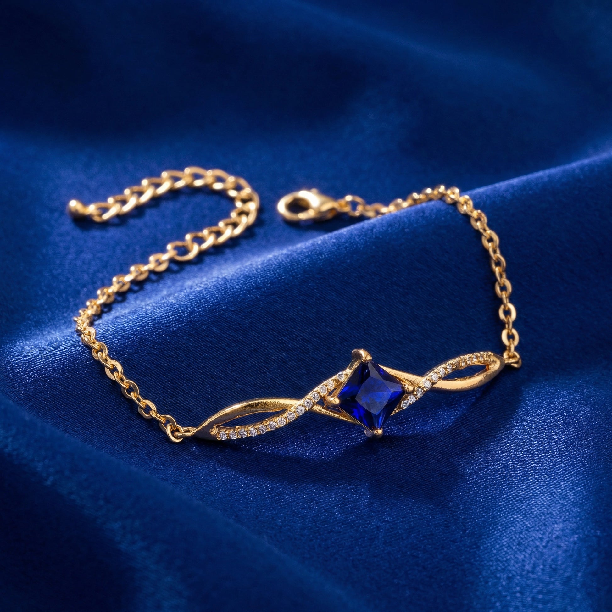 18k Gold Plated bracelet with a blue gemstone on a blue fabric background
