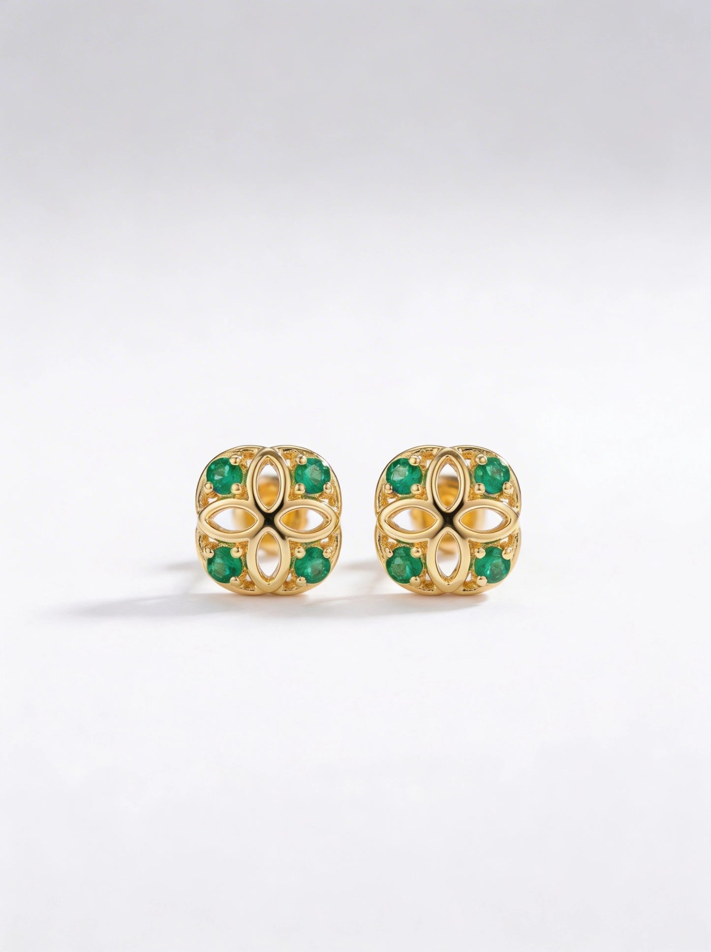 18k gold plated earrings with green gemstones on a white background