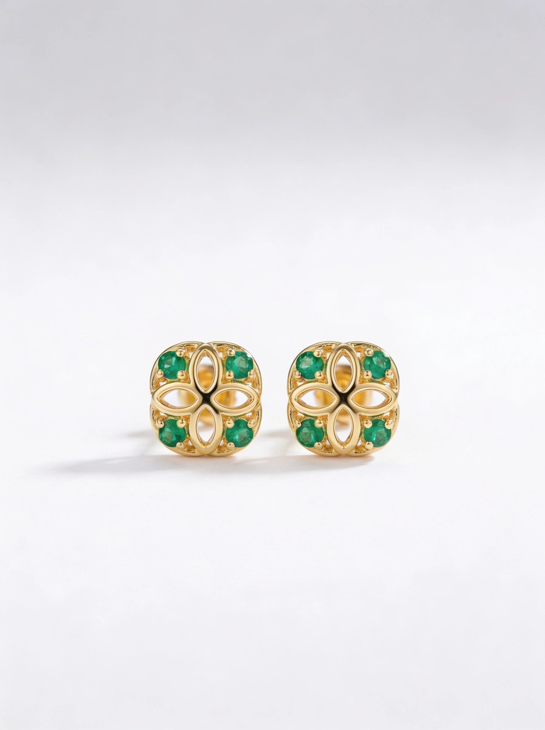 18k Gold plated earrings with green gemstones on a white background