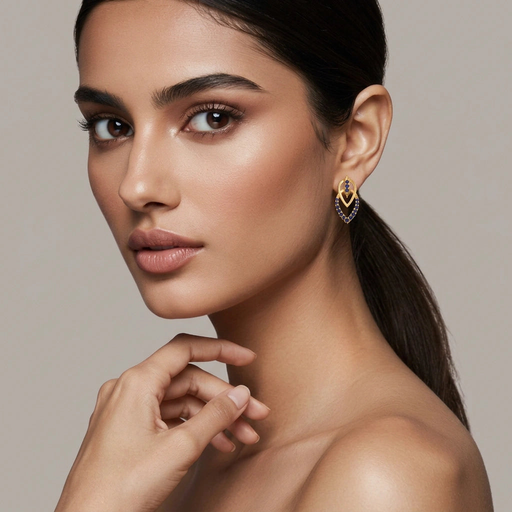 woman wearing a 18k gold plated earring with a beige background