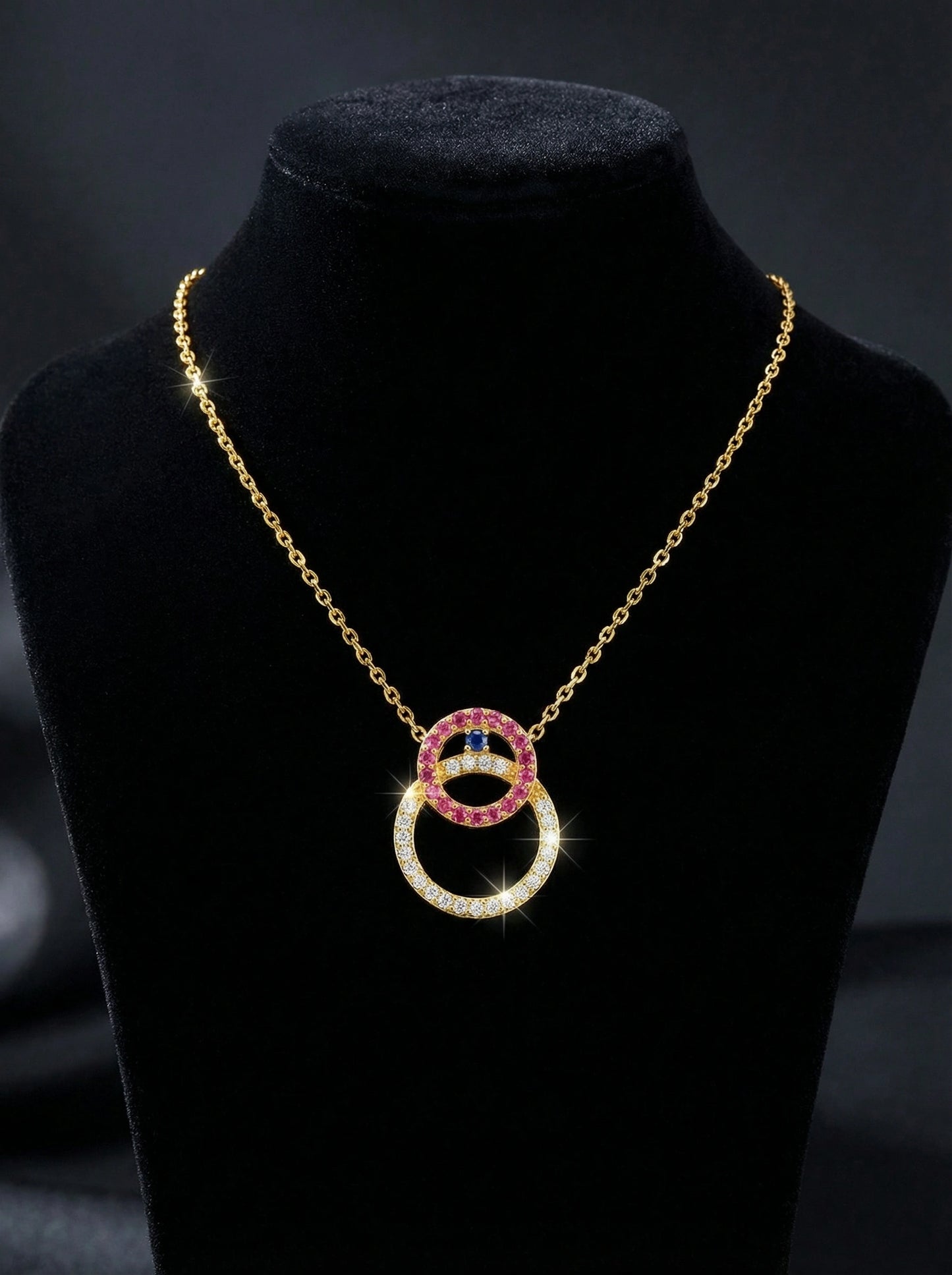 18k gold plated necklace with interlocking rings on a black stand against a dark background