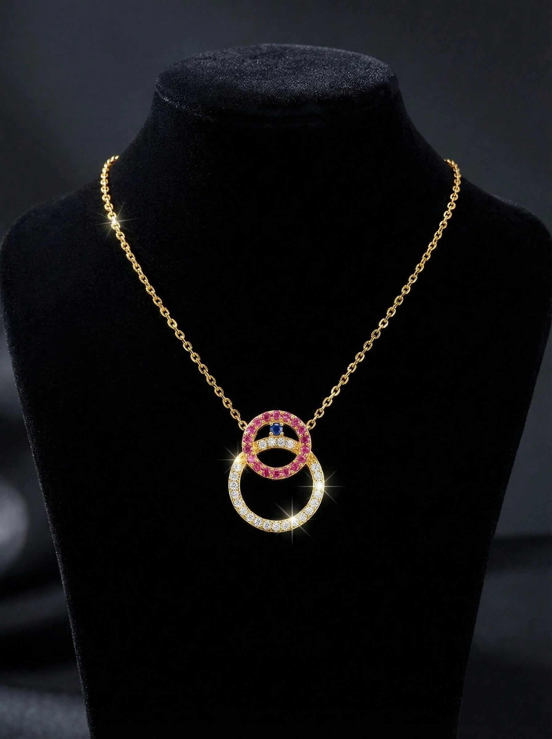 18k gold plated Necklace with interlocking rings on a black stand against a dark background