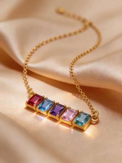 18k Gold plated necklace with colorful gemstones on a beige fabric background