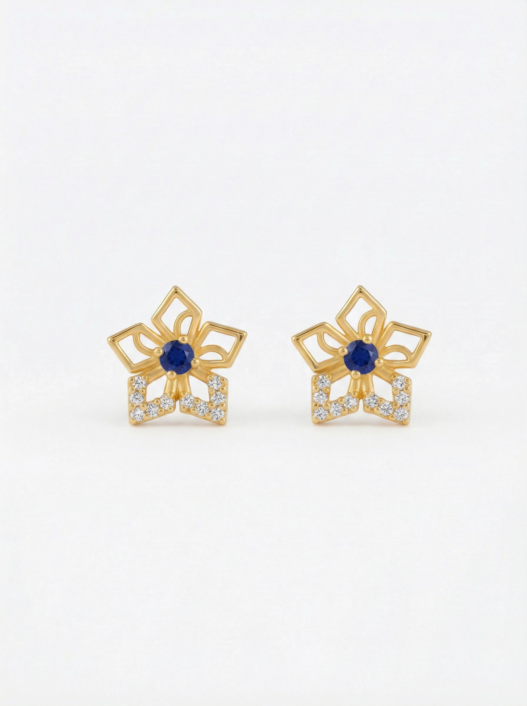Pair of 18k gold plated earrings with blue gemstones on a white background