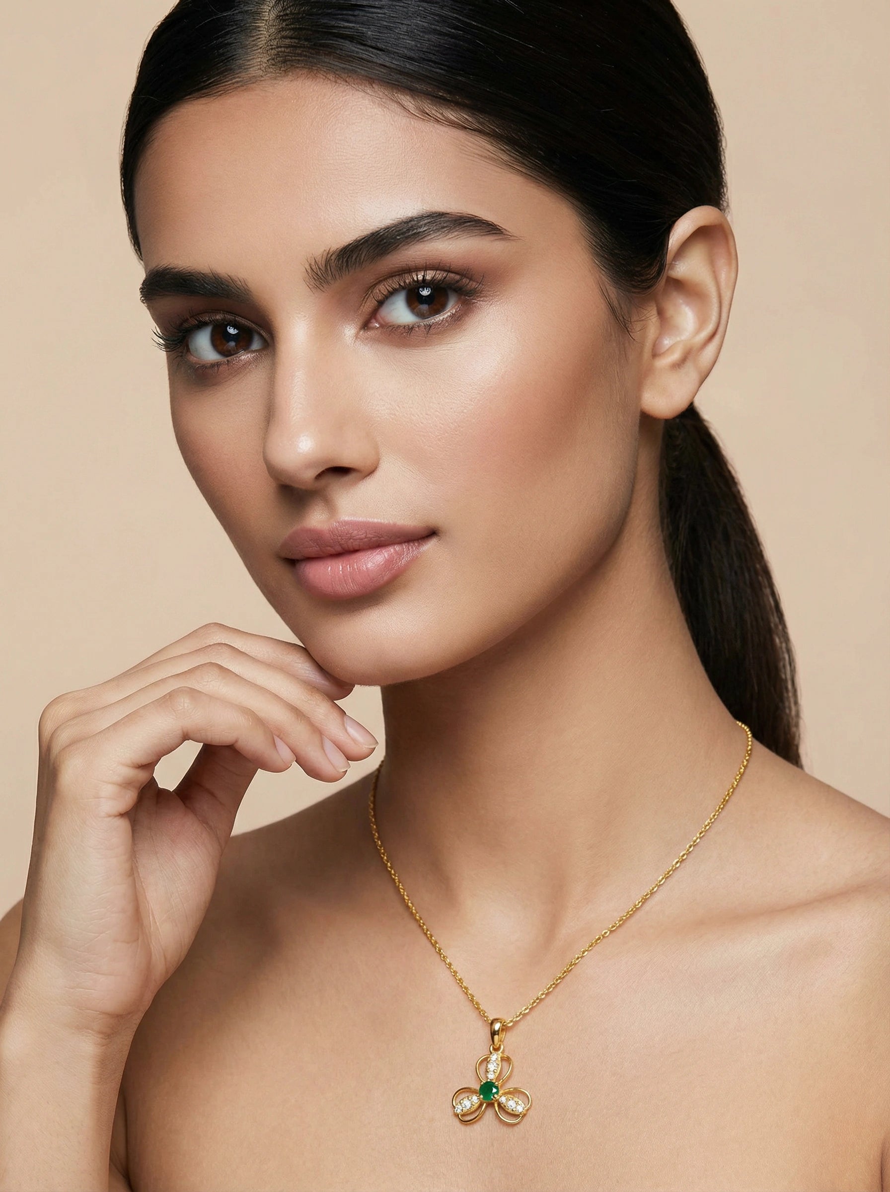 Woman wearing a 18k gold plated necklace with a pendant against a beige background