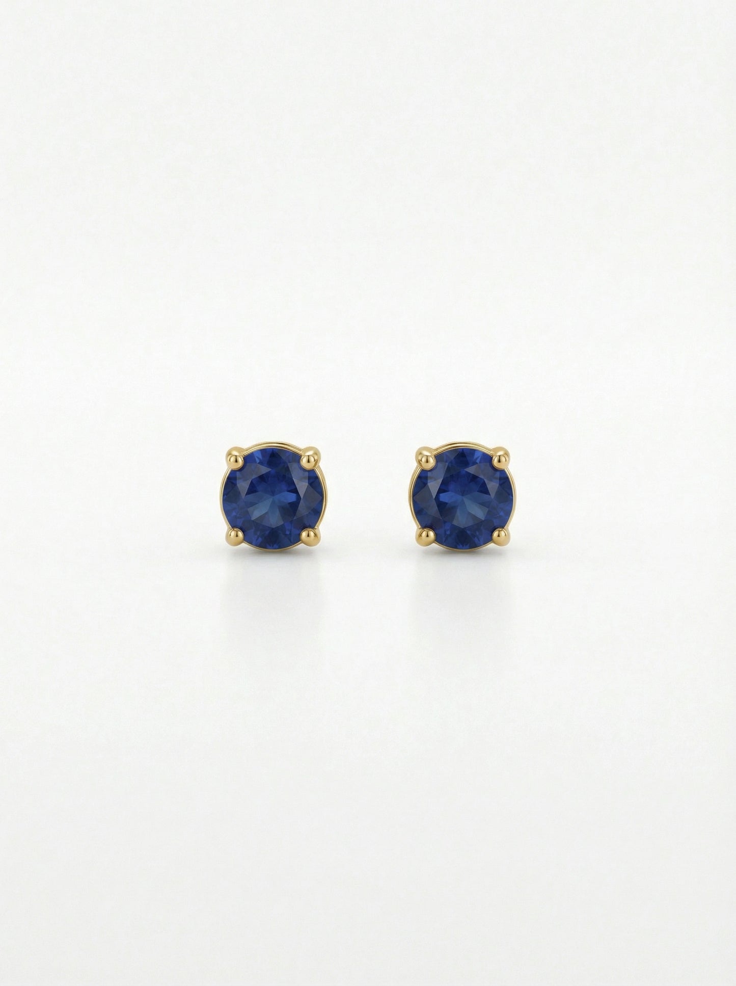 pair of 18k gold plated earrings with blue gemstones on a white background
