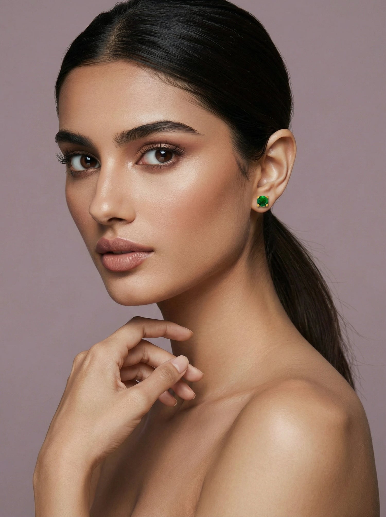 Woman wearing green earrings 18k gold plated against a neutral background 