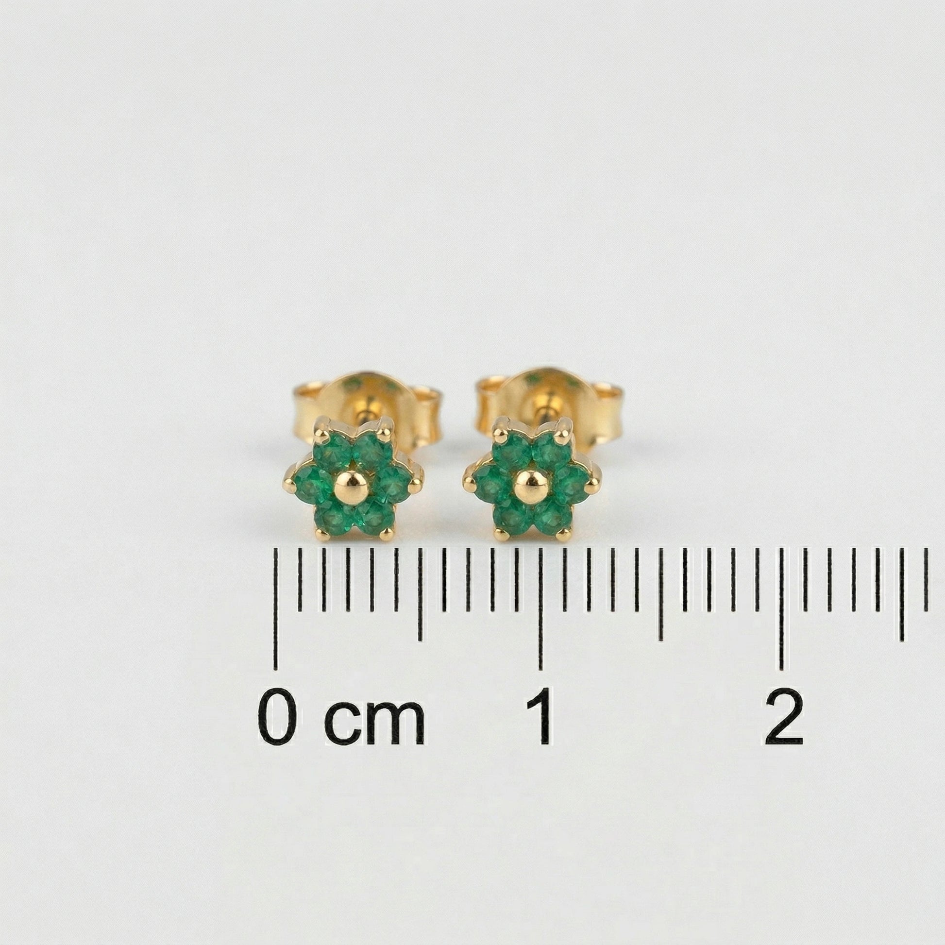 18k Gold plated earrings with green gemstones on a white background with measurement scale.