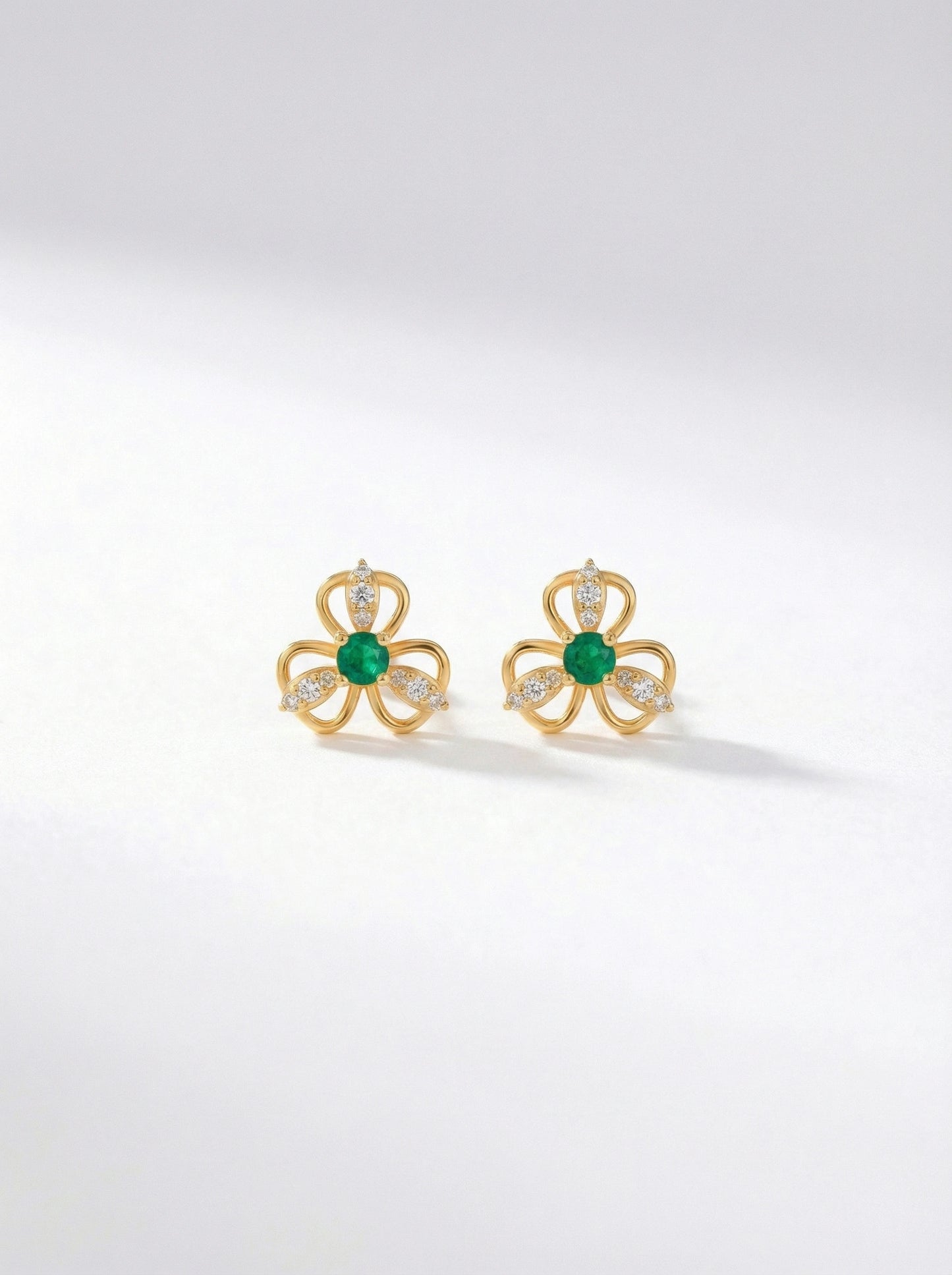 18k gold plated earrings with green gemstones on a white background