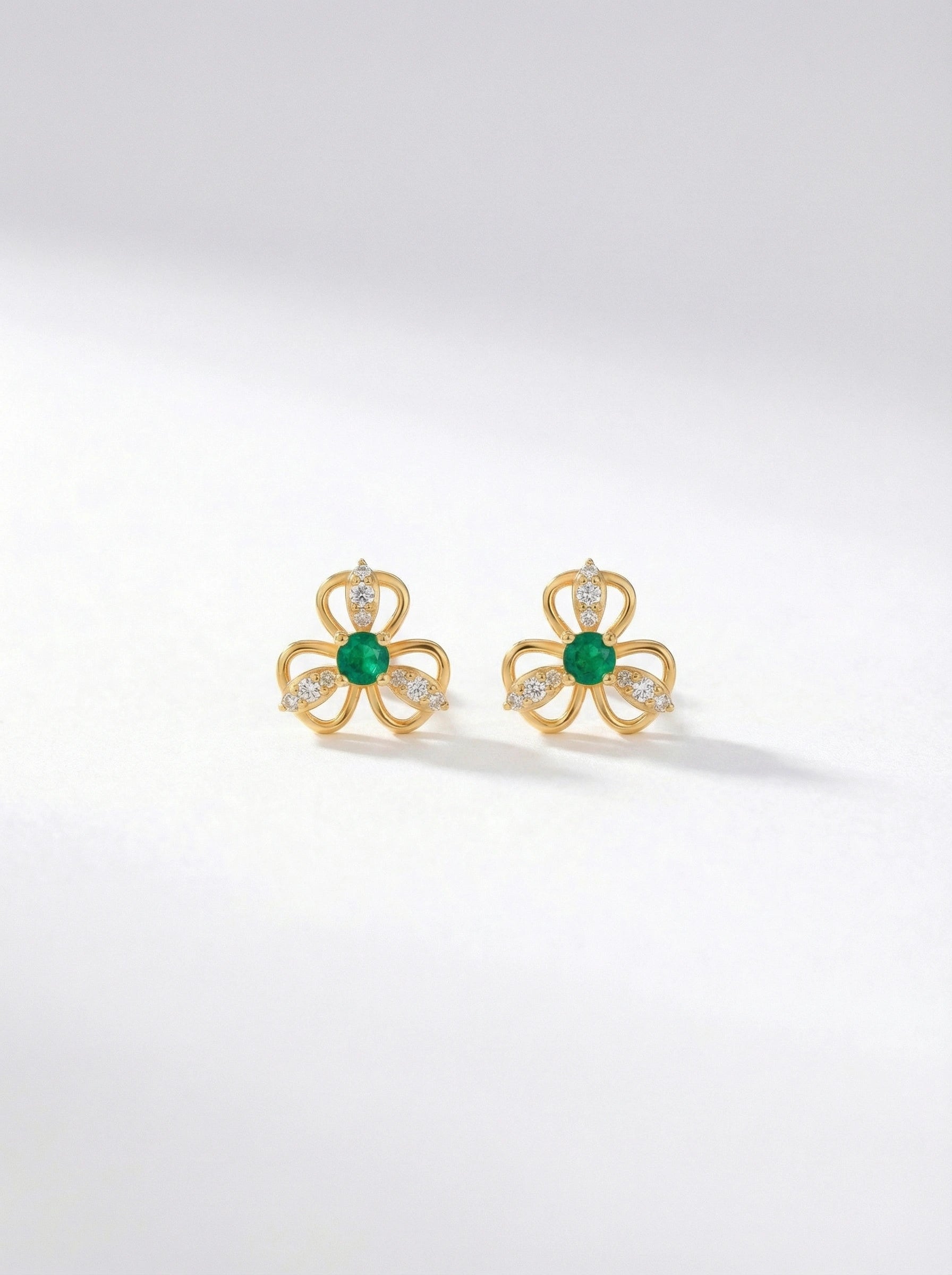 18k Gold plated earrings with green gemstones on a white background