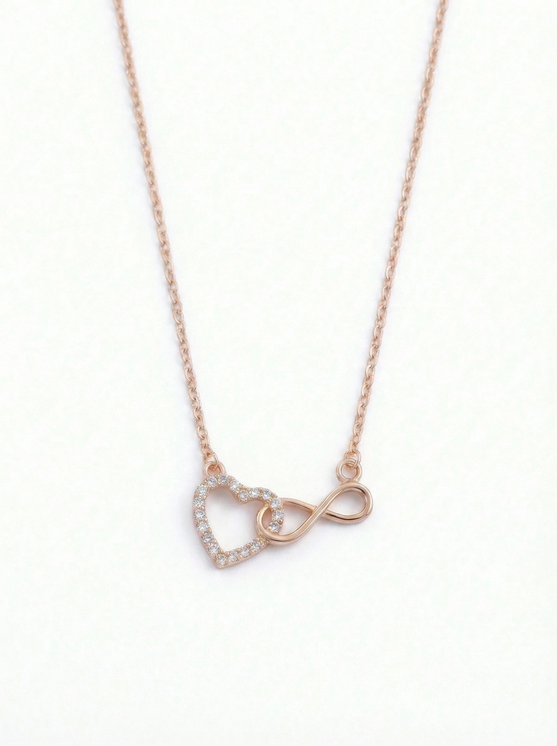  18k rose gold plated necklace with heart and infinity symbol pendant on a white background