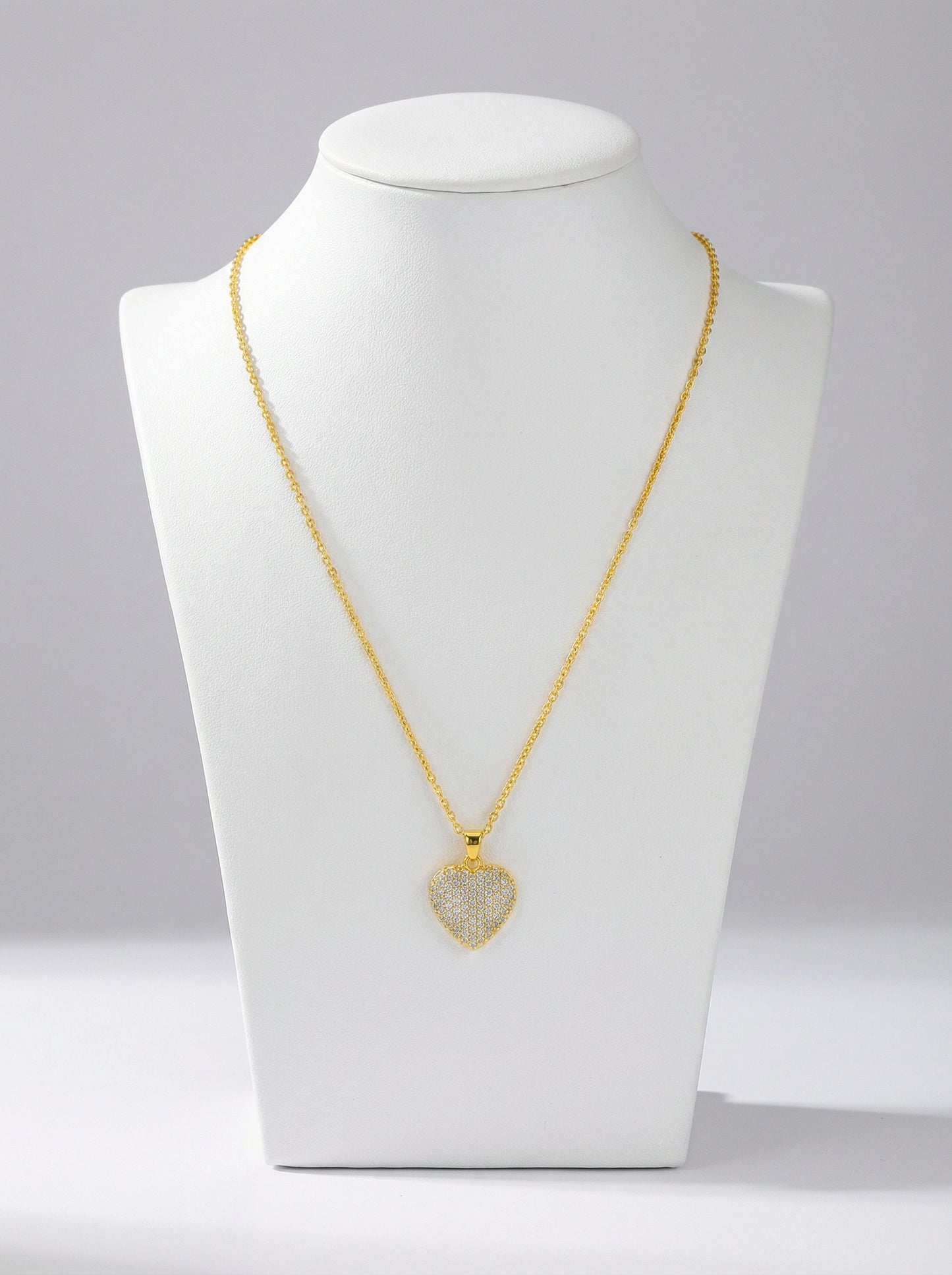 18k gold plated necklace with a heart-shaped pendant on a white mannequin bust against a gray background