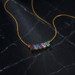 18k Gold plated necklace with colorful gemstones on a dark marble surface