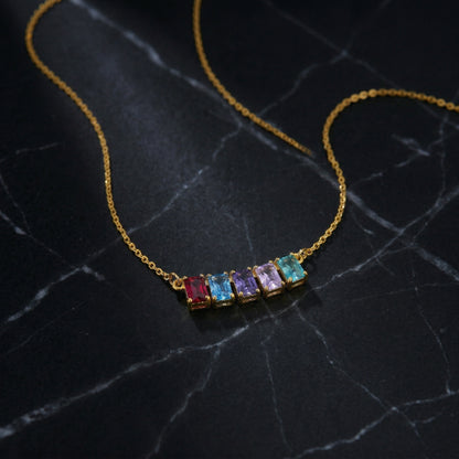 18k Gold plated necklace with colorful gemstones on a dark marble surface