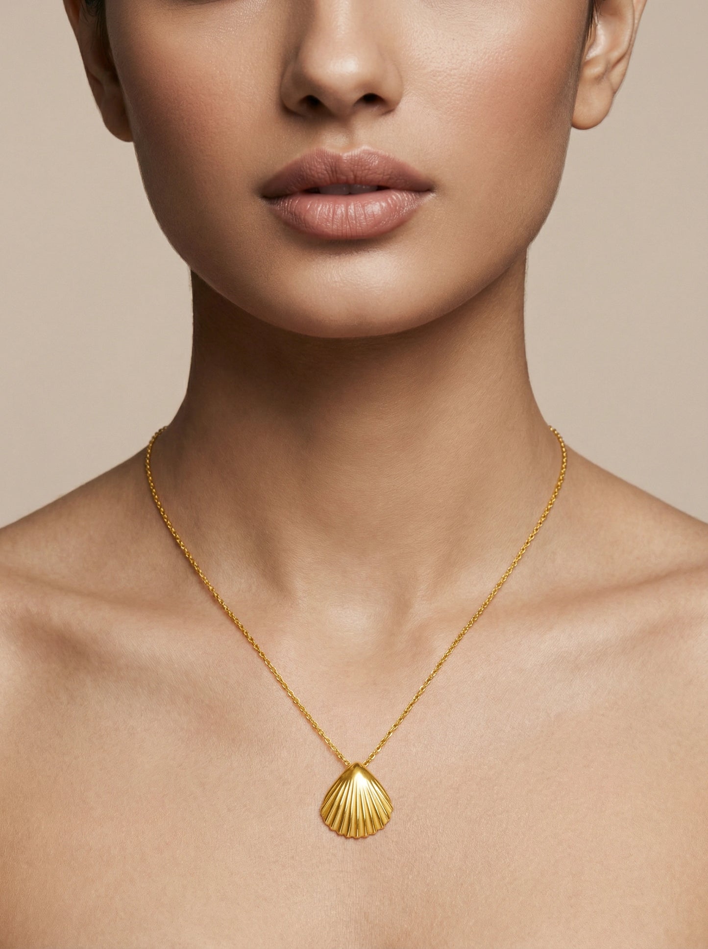 18k gold plated necklace with a shell pendant on a neutral background