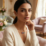 Woman wearing 18k gold plated  a colorful necklace in a cozy living room setting