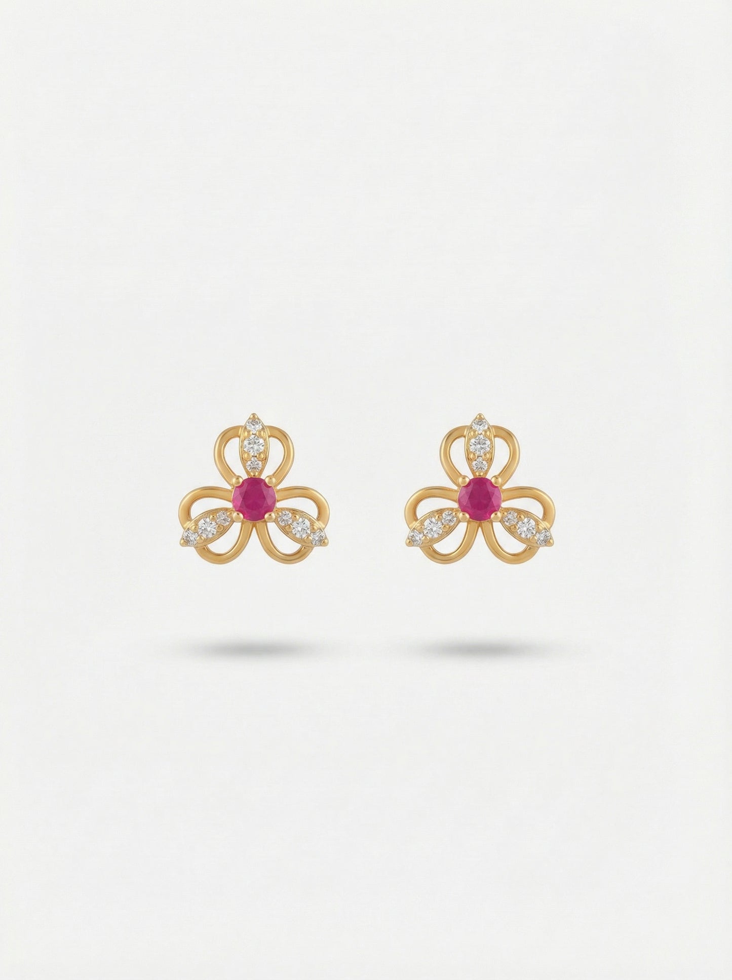 18k gold plated bow-shaped earrings with red gemstones on a white background