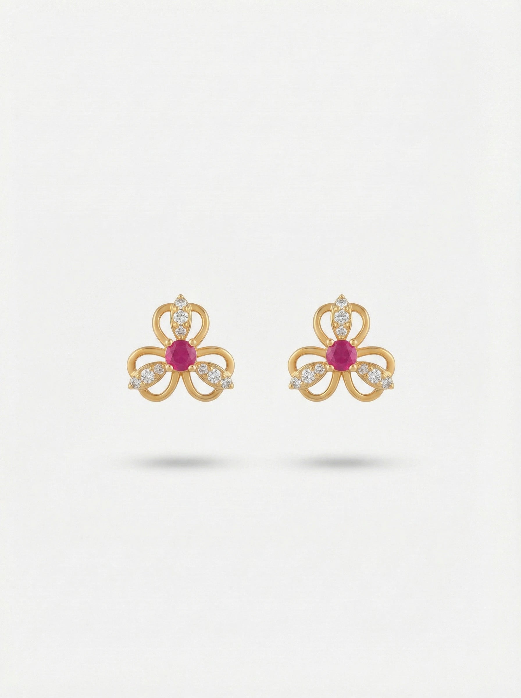 18k Gold plated bow-shaped earrings with red gemstones on a white background