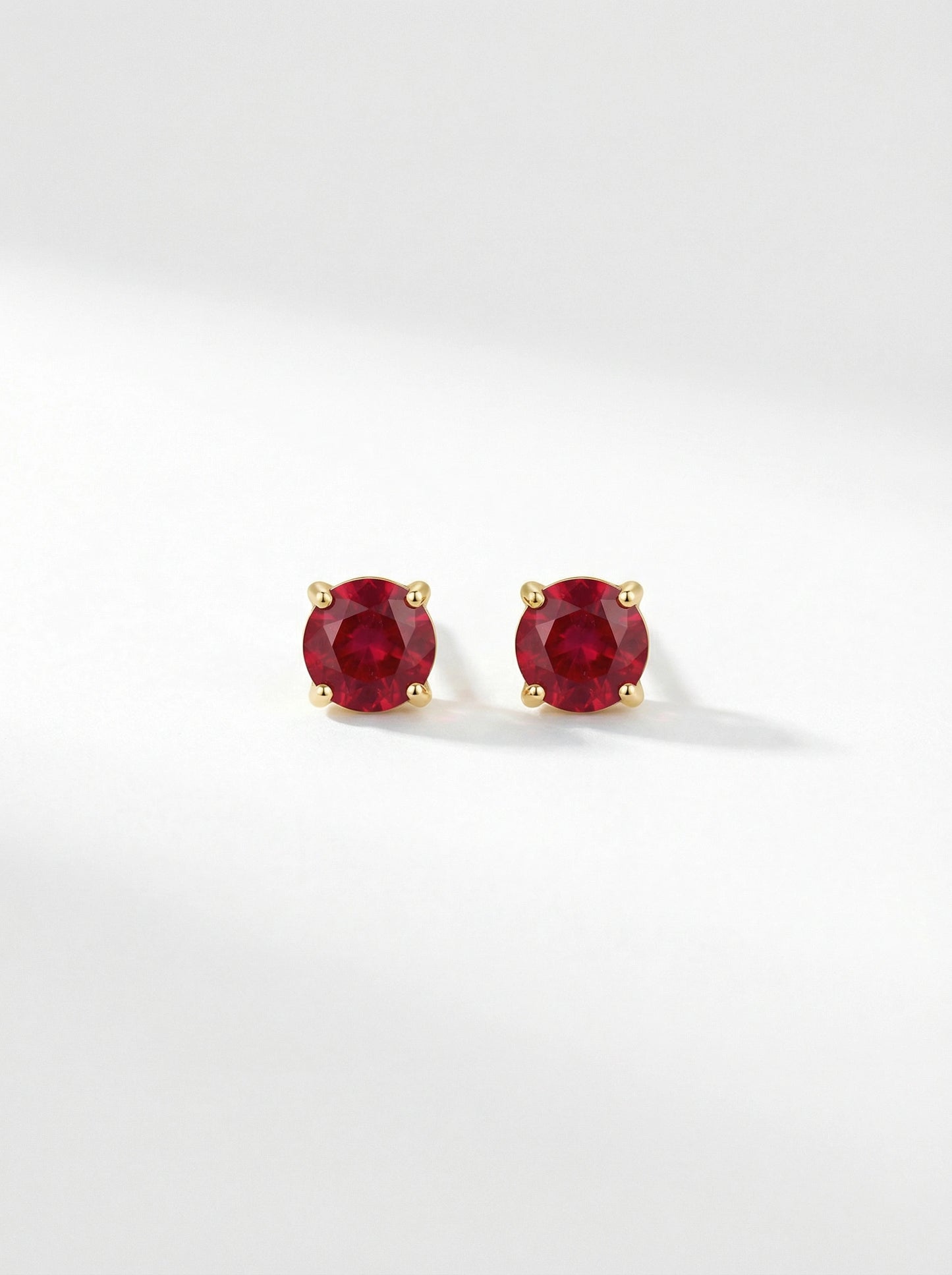 pair of18k gold plated  red gemstone stud earrings on a white background