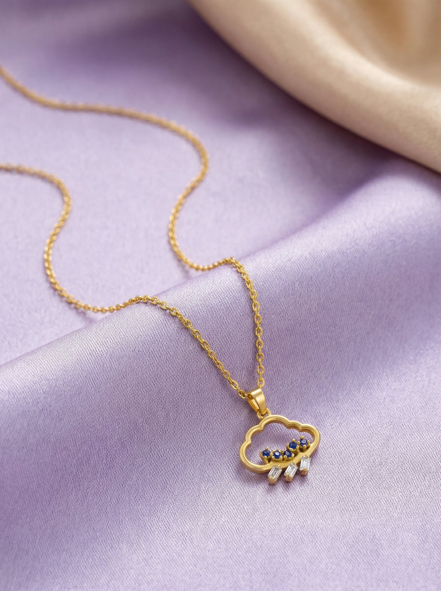 18k gold  plated necklace with a cloud-shaped pendant on a purple fabric background