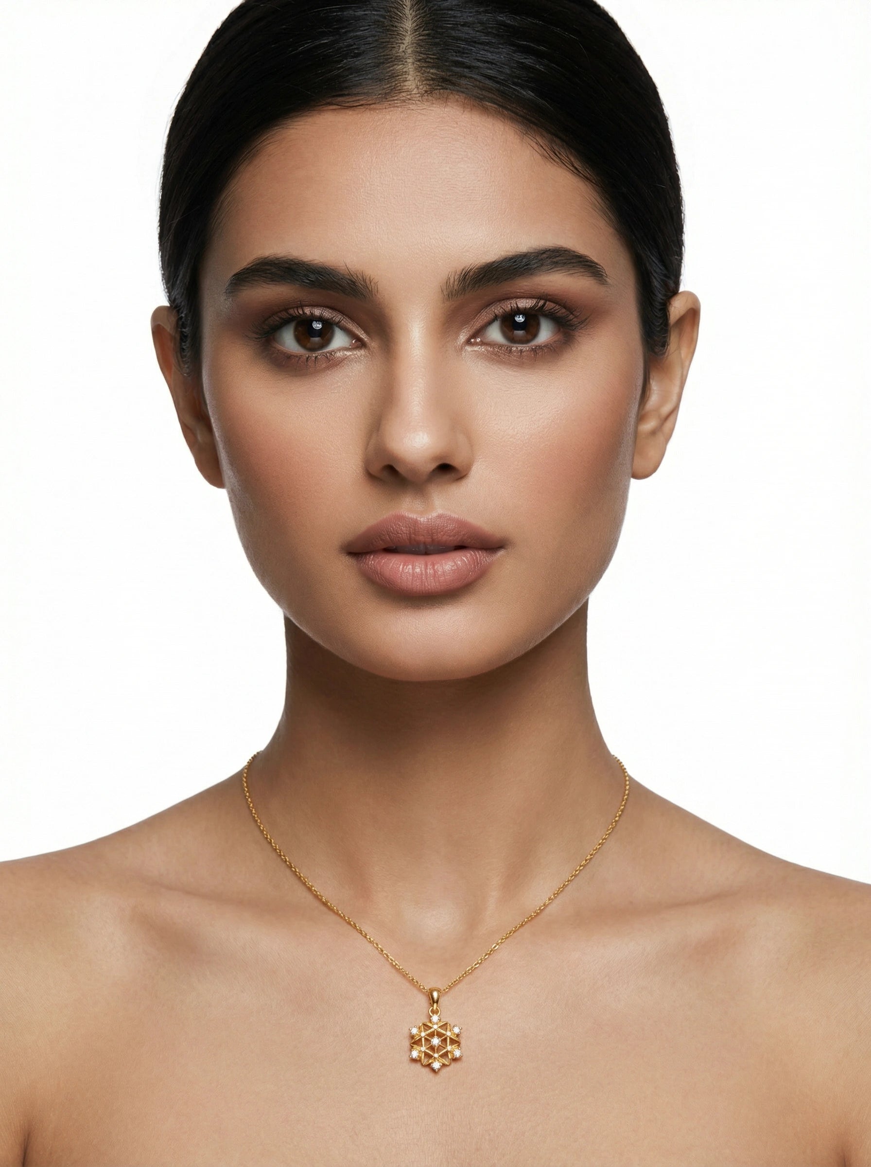 Woman wearing a 18k gold plated necklace with a snowflake pendant on a white background