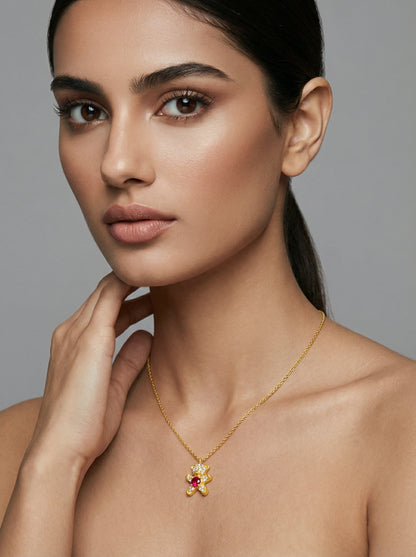 Woman wearing a 18k gold plated necklace with a pendant against a neutral background