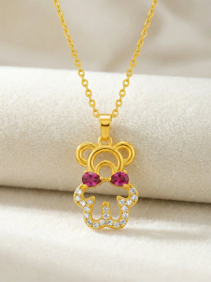 18k Gold plated pendant with red gemstones on a beige background