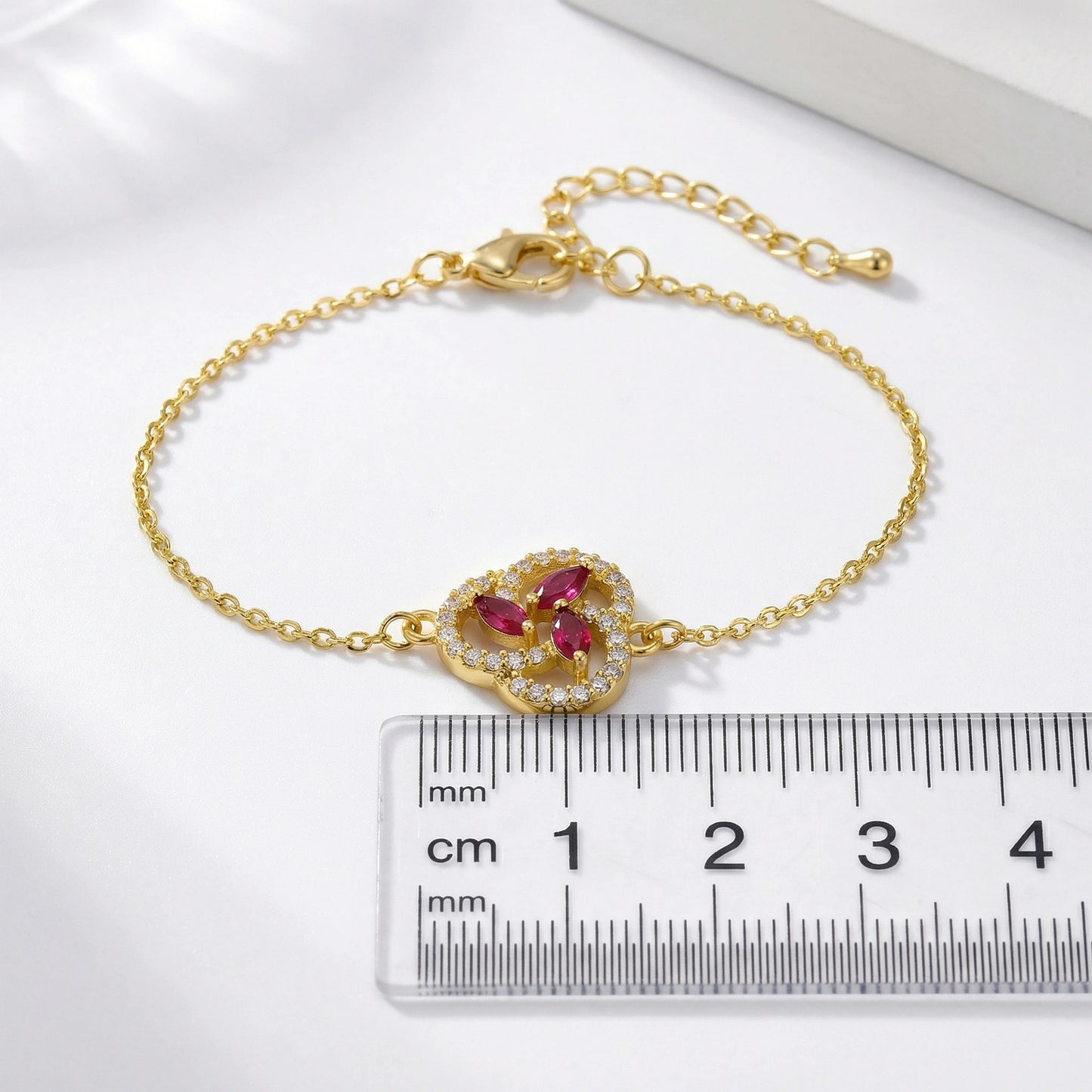 18k gold plated bracelet with gemstones next to a ruler on a white background