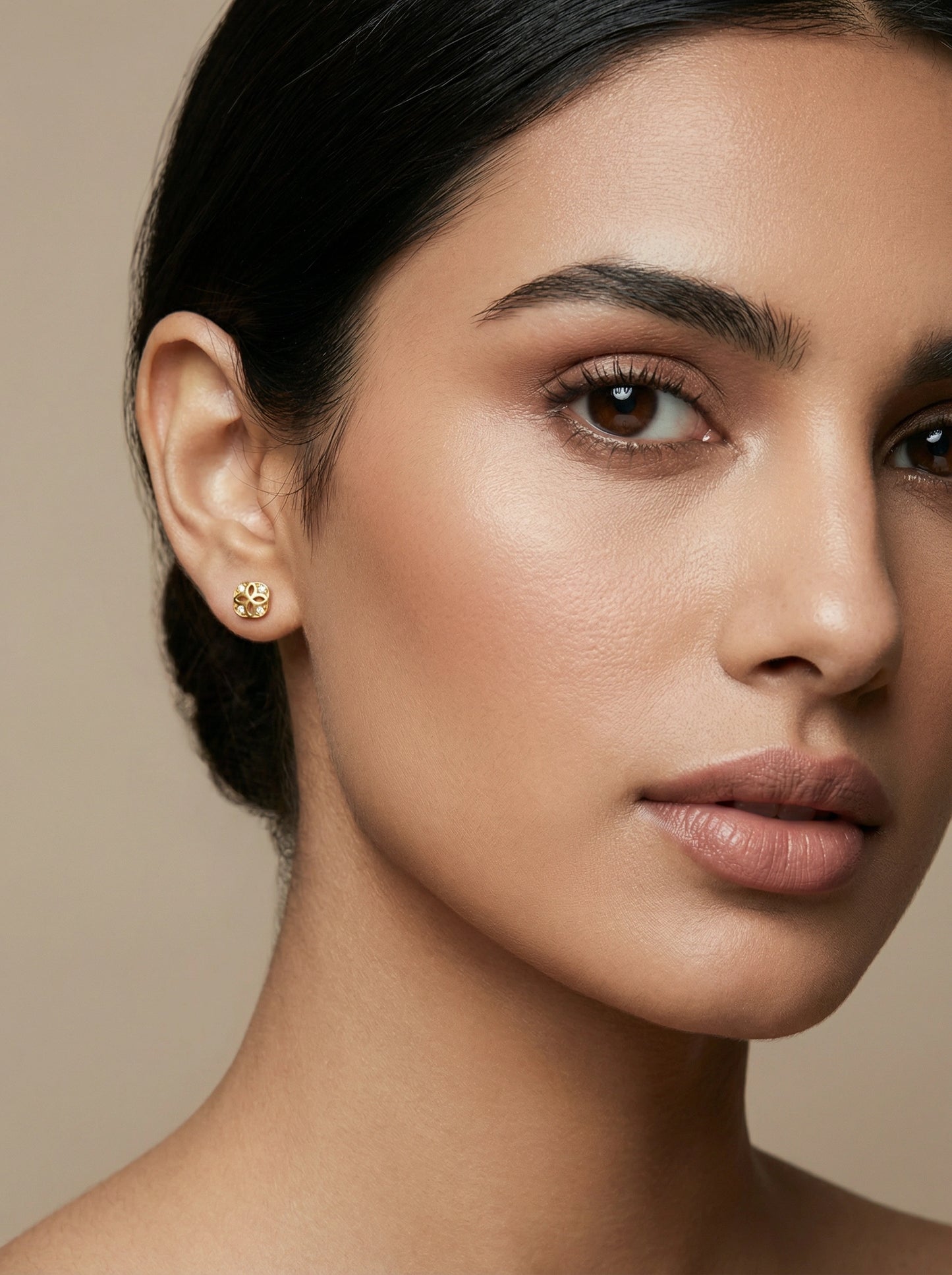 close-up of a woman's face with a neutral background  wear 18k gold plated white gemstone earing stud 