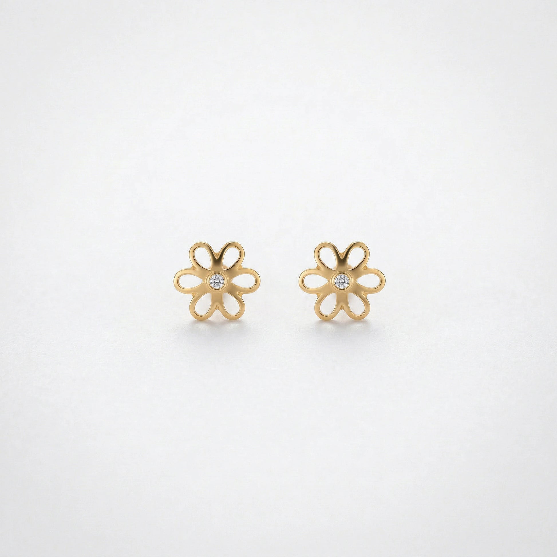 18k Gold plated flower-shaped earrings on a light gray background